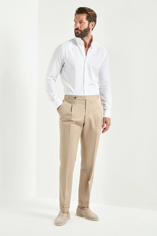 Man wearing a white dress shirt and beige pants on a white background