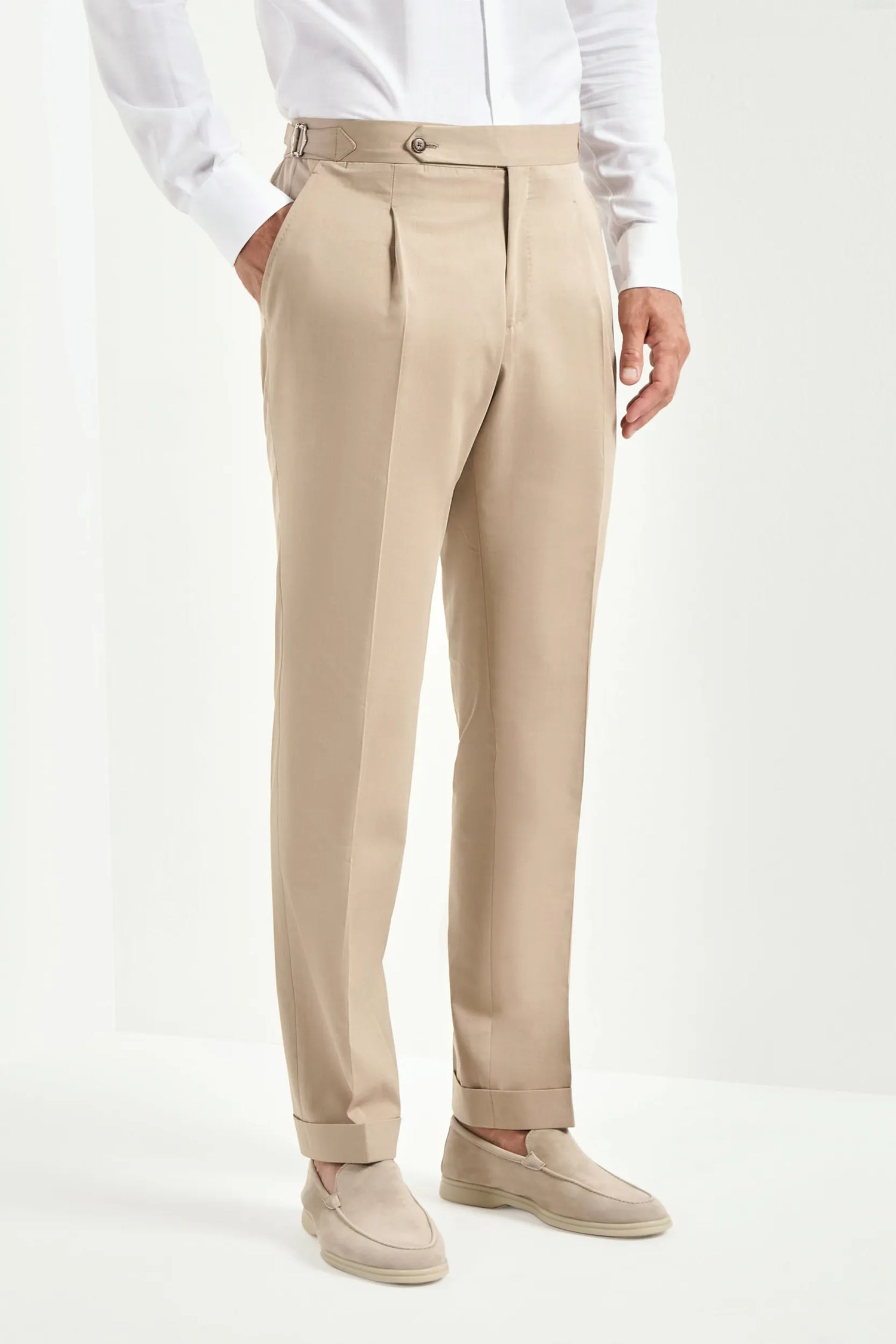 Beige pants worn by a person on a white background