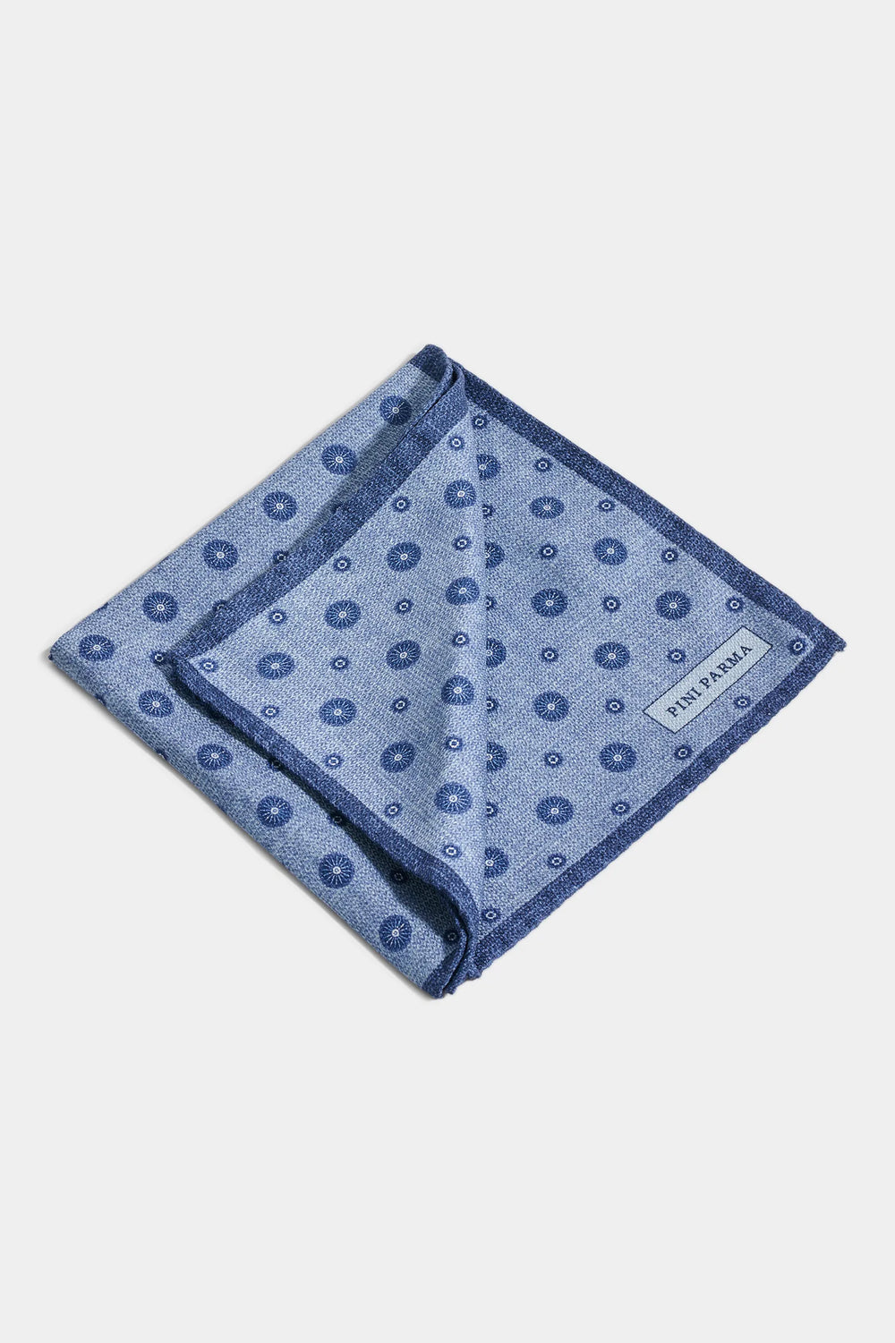 Blue patterned pocket square on a light gray background