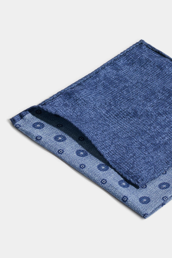 Blue patterned pocket square on a light gray background