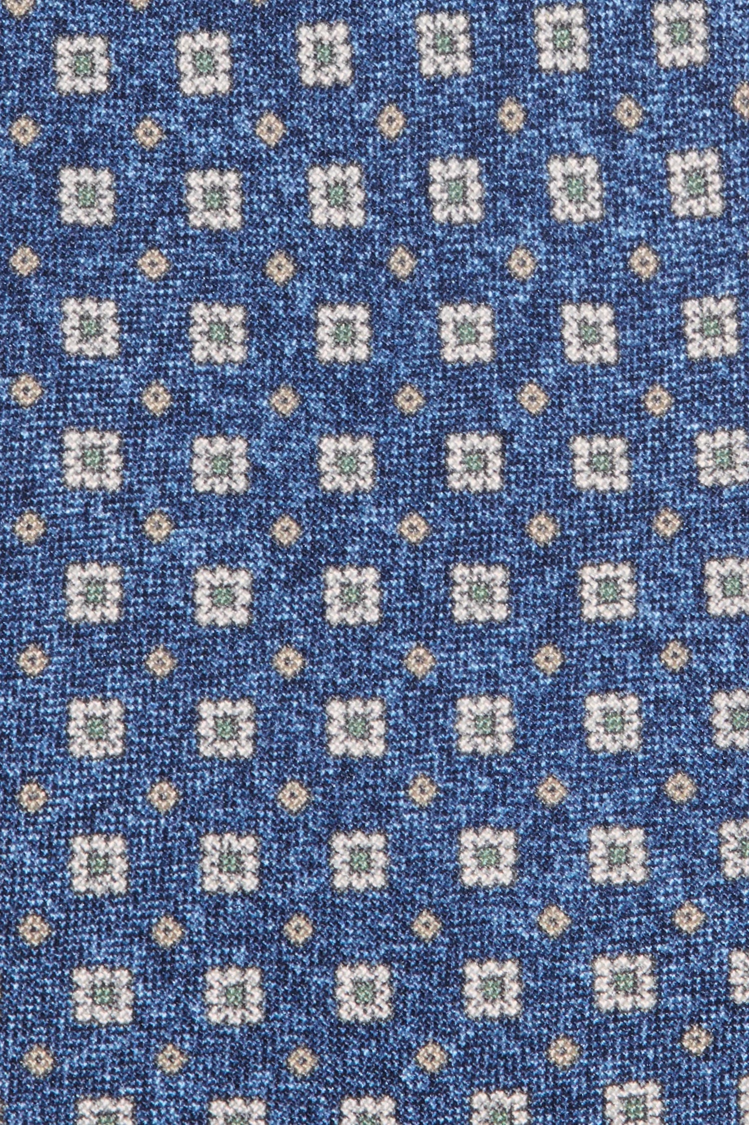 Close-up of a blue fabric with a pattern of small squares and dots.