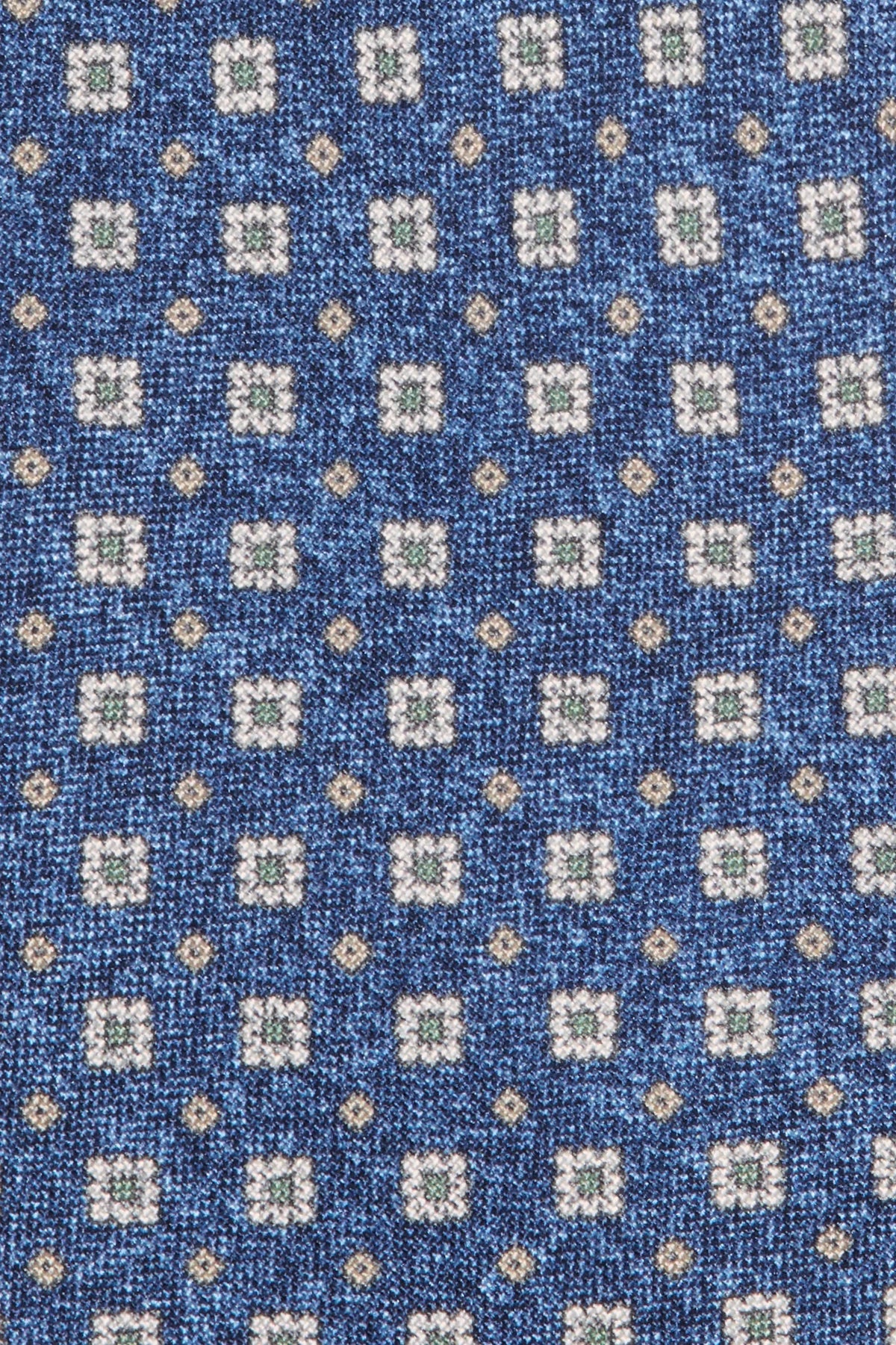Close-up of a blue fabric with a pattern of small squares and dots.
