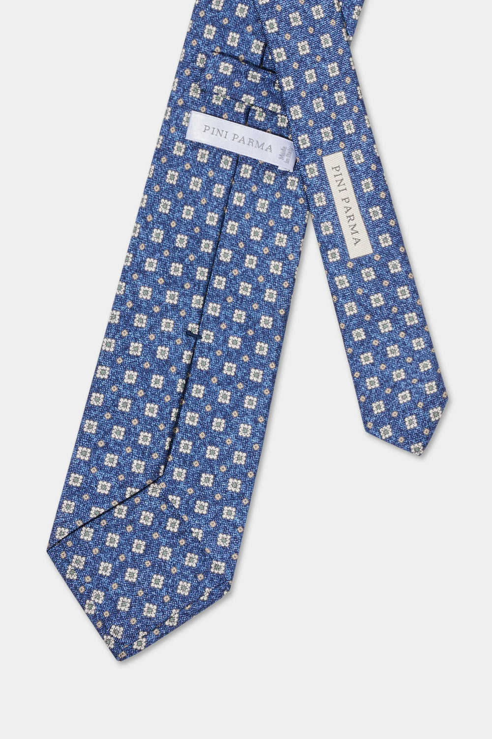 Blue patterned tie with brand label on a light gray background
