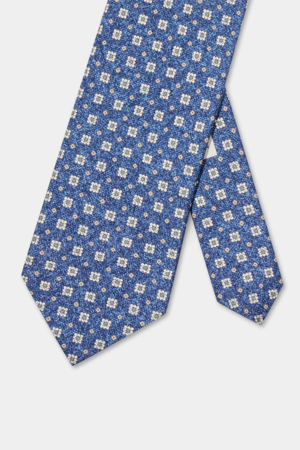 Blue patterned tie on a light gray background
