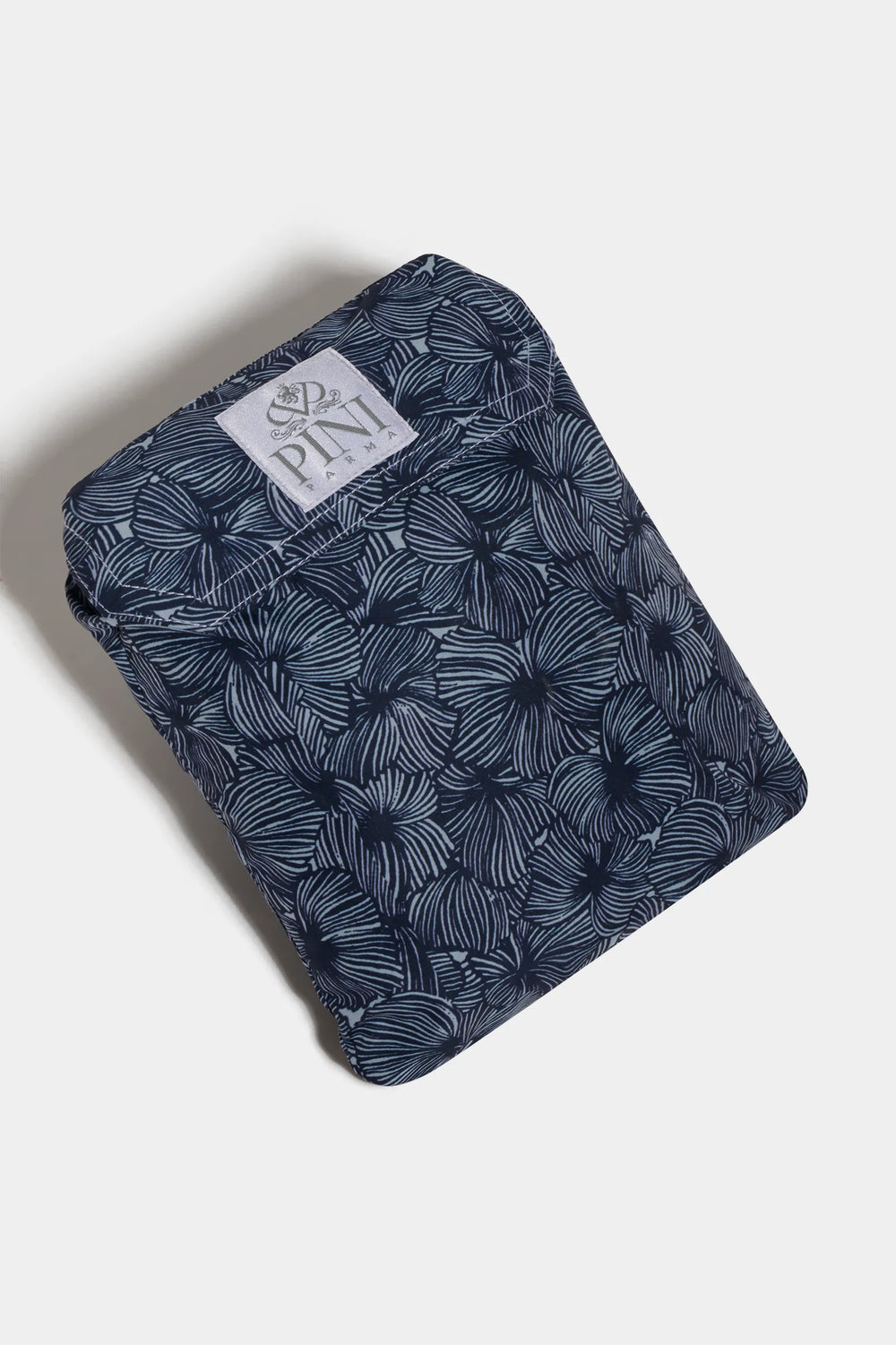 Folded blue patterned fabric with a visible brand label on a white background