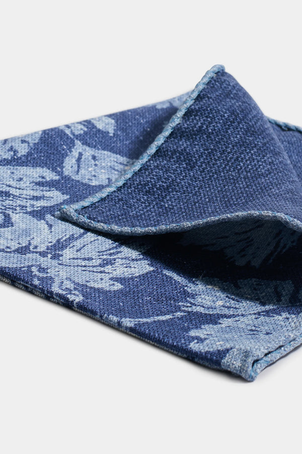 Folded blue fabric with a pattern on a light gray background