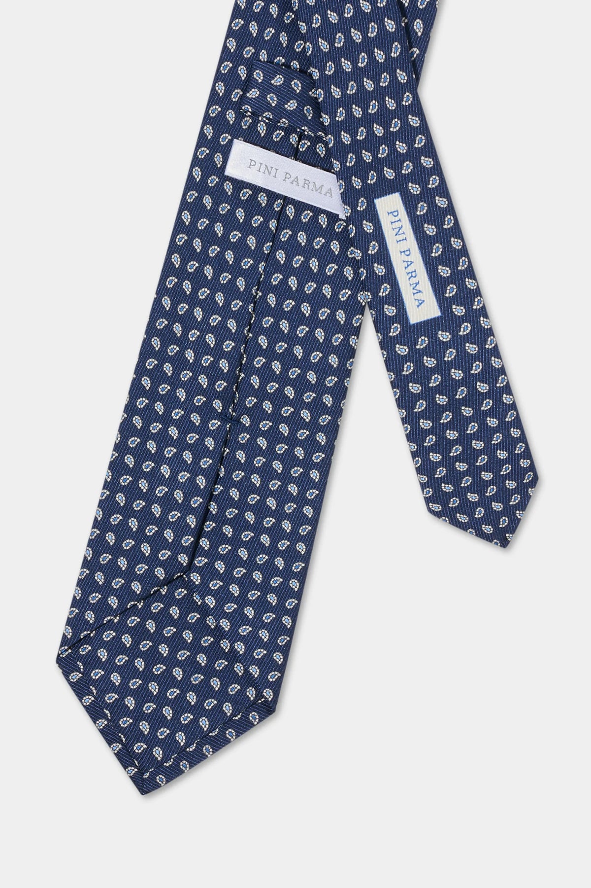 Navy blue tie with white pattern on a light gray background