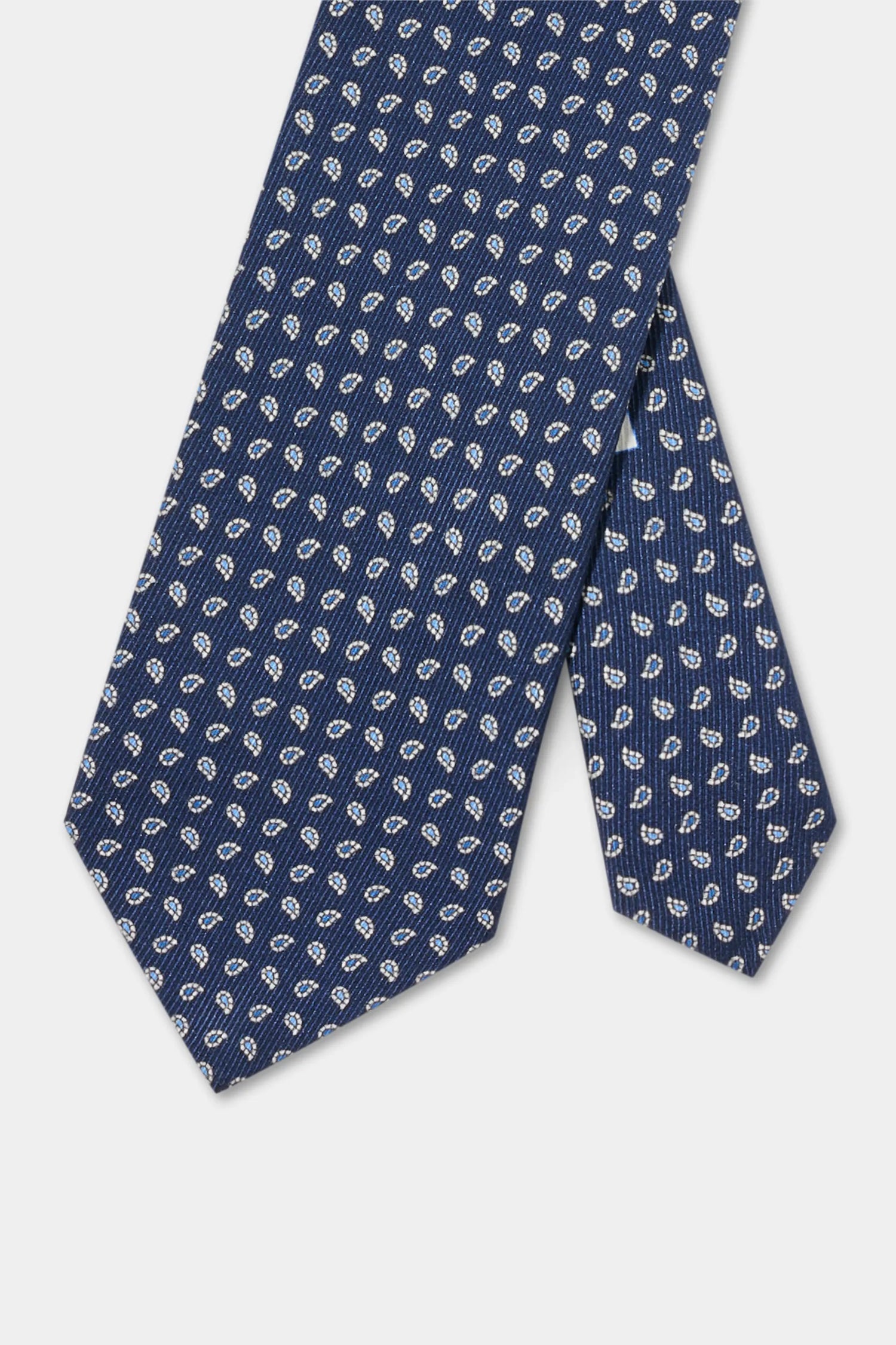 Navy blue tie with white pattern on a light gray background