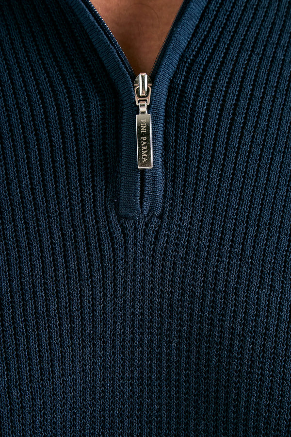 Close-up of a navy blue ribbed sweater with a zipper