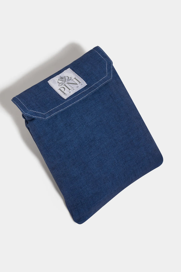 Folded blue denim fabric with a visible brand label on a white background