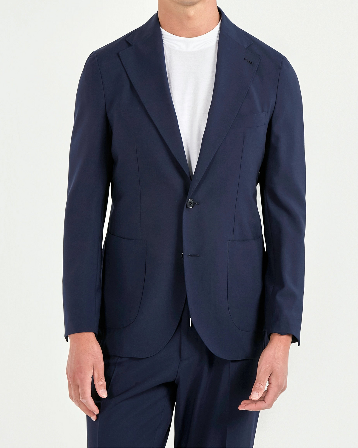Man wearing a navy suit and sunglasses on a white background