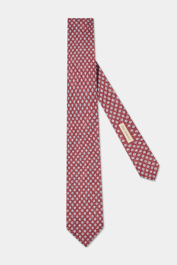 Red patterned tie with a brand label on a white background