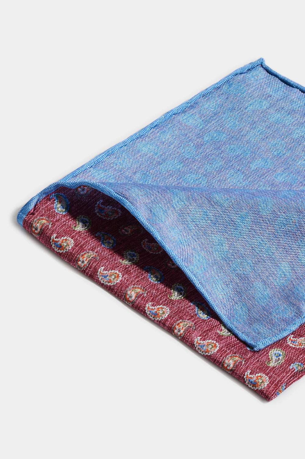 Folded blue and red patterned fabric on a white background