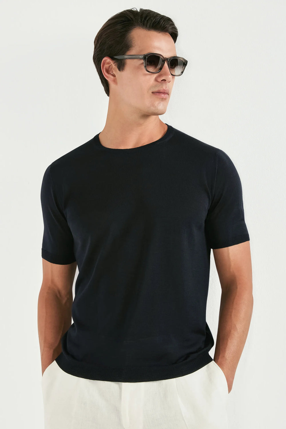 Man wearing a black t-shirt and sunglasses on a white background