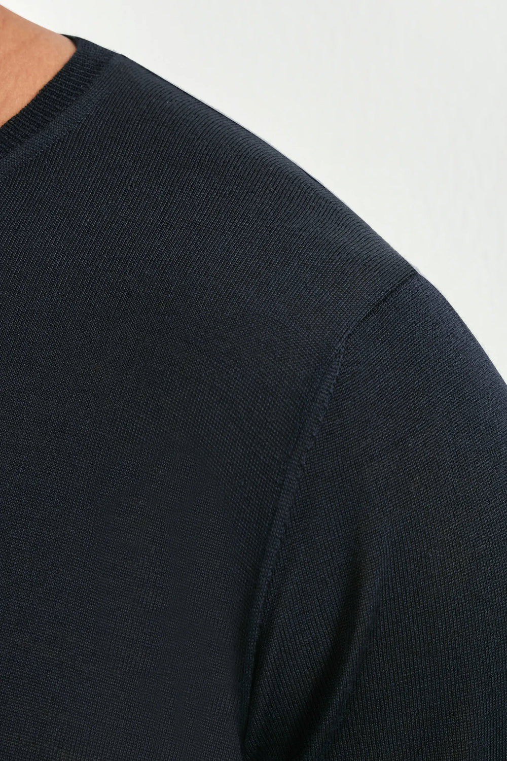 Close-up of a black sweater sleeve on a white background