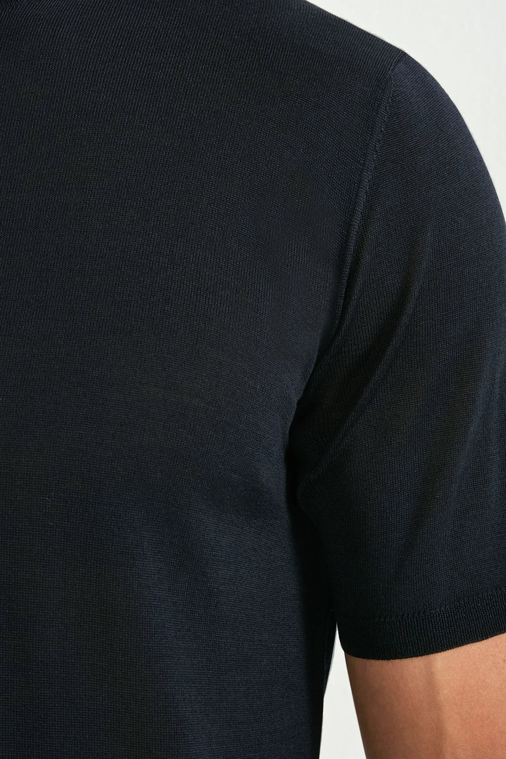 Black t-shirt worn by a person on a white background