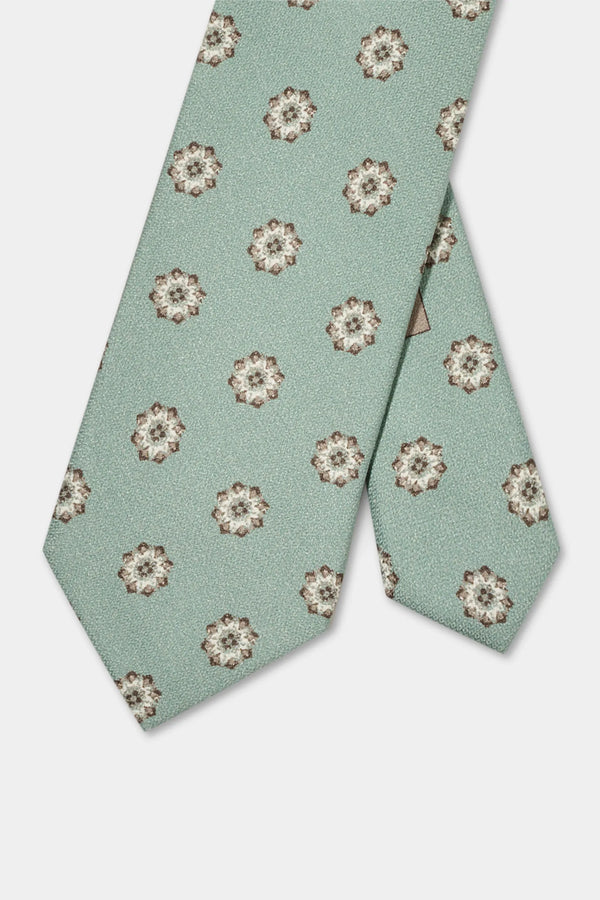 Green floral patterned tie on a light gray background
