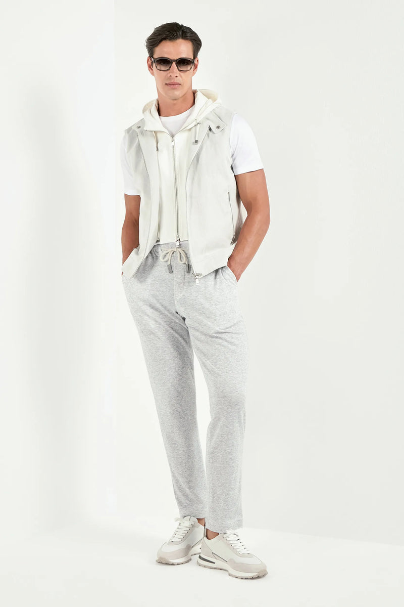 Man wearing a white outfit with gray pants on a white background