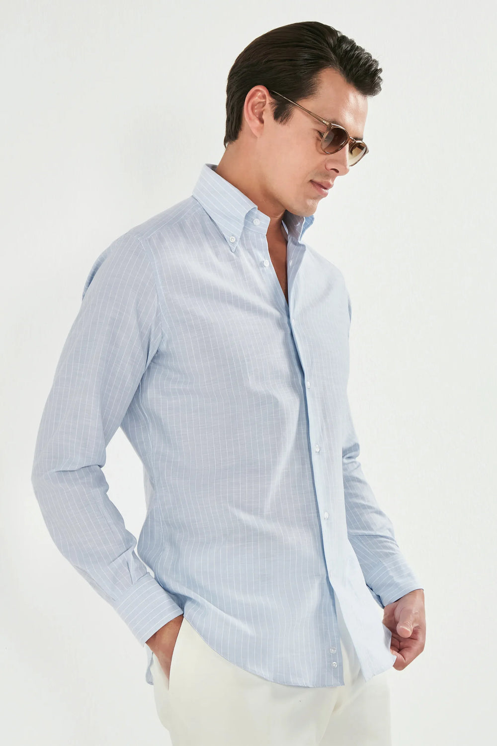 Man wearing a light blue striped shirt against a white background