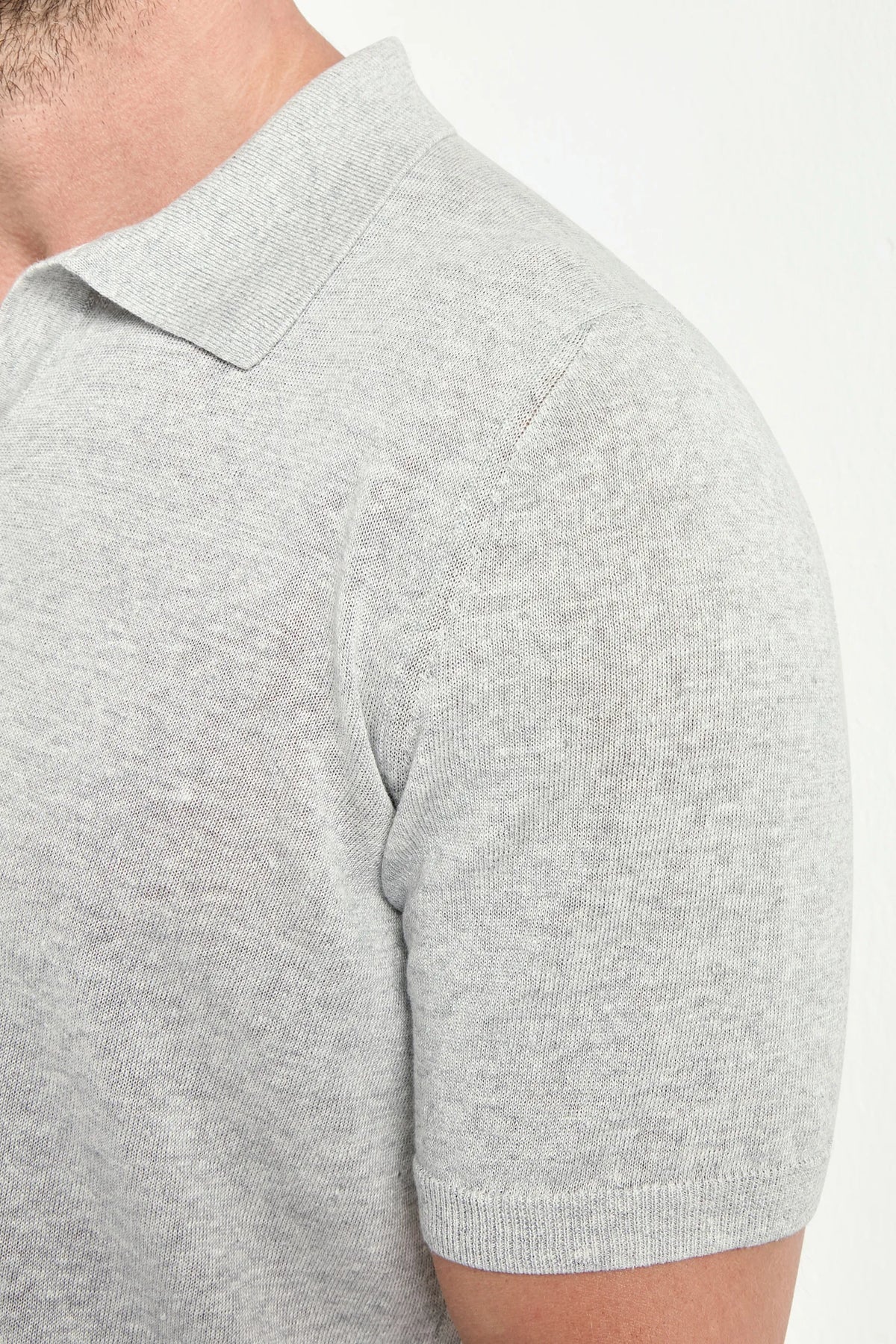 Gray short-sleeve shirt worn by a person on a white background