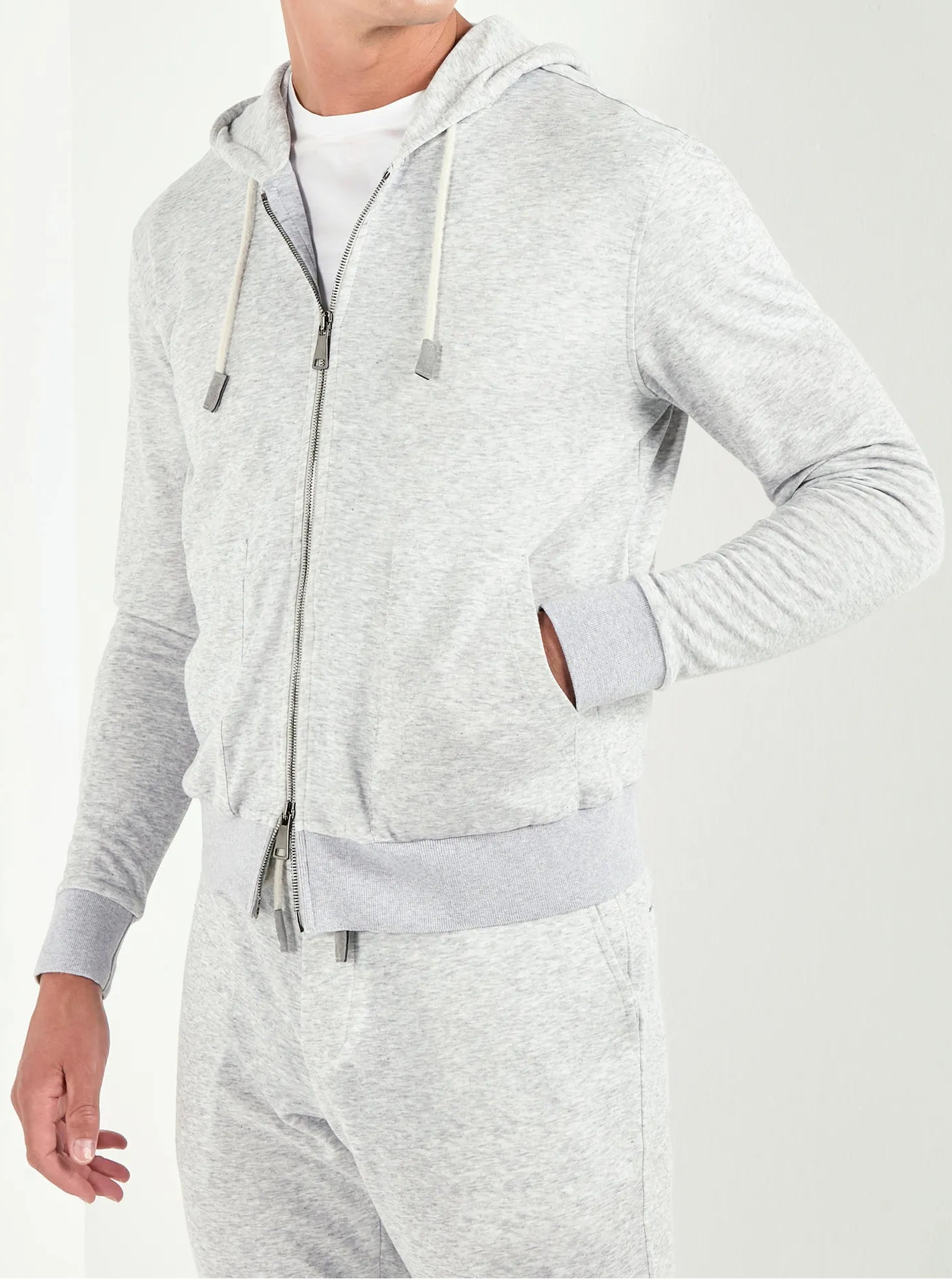Man wearing a gray hoodie and pants on a white background