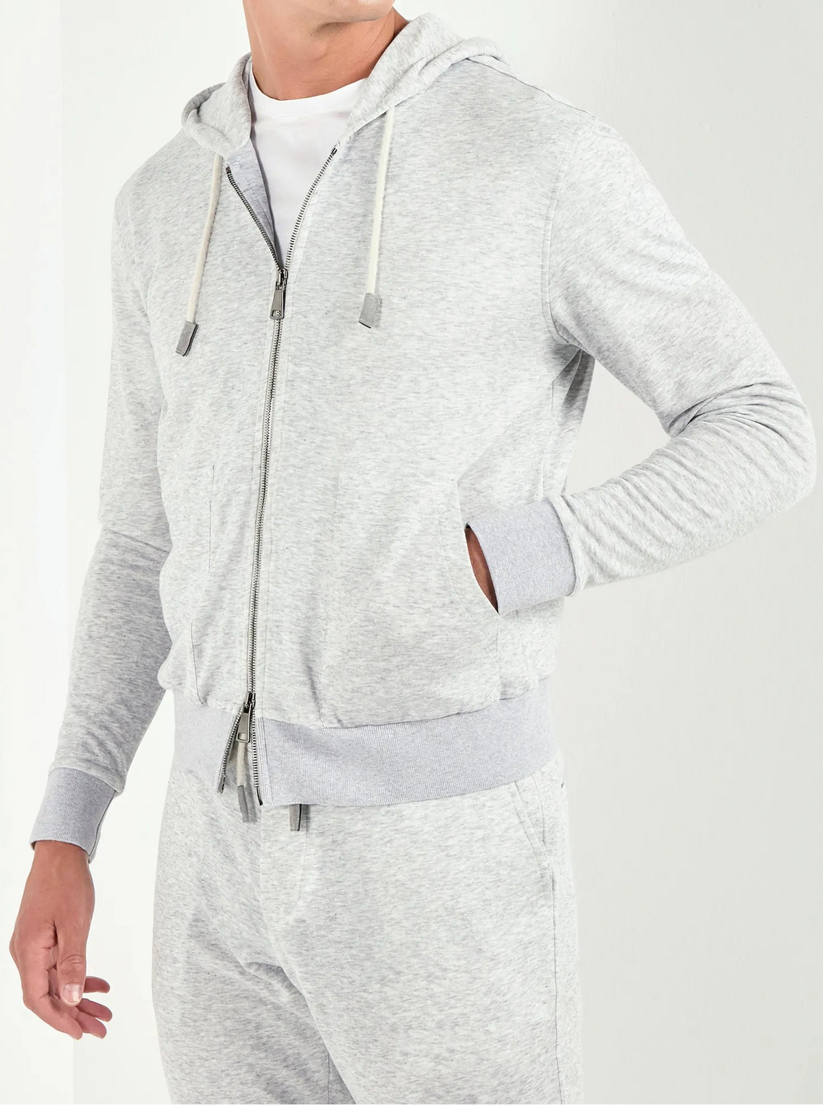 Man wearing a gray hoodie and pants on a white background