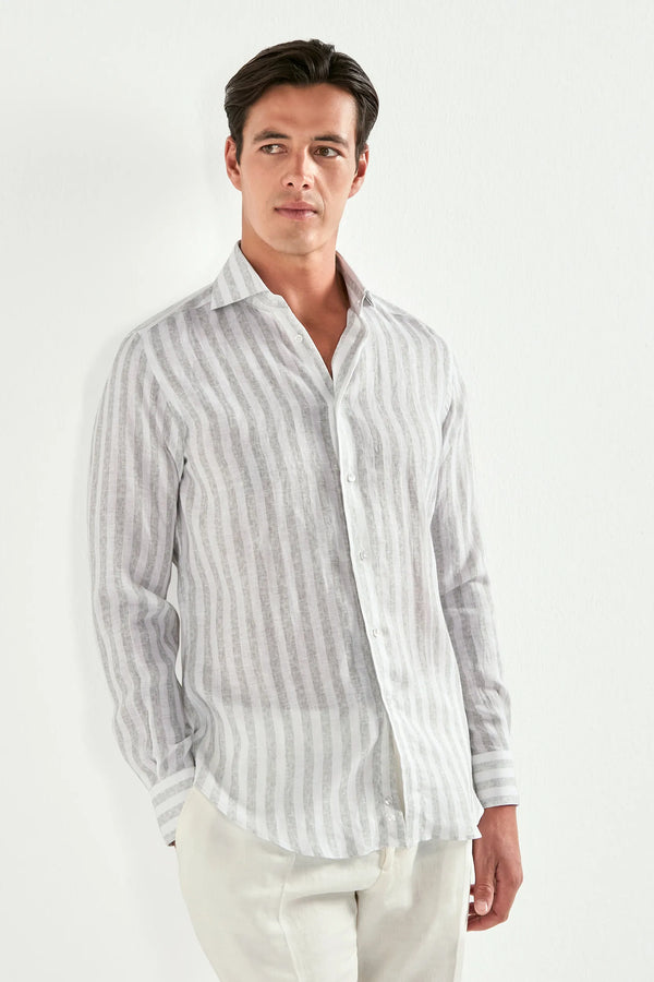 Man wearing a striped shirt and white pants on a plain background