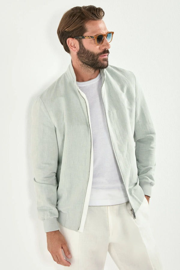 Man wearing a light green jacket over a white shirt and pants on a white background