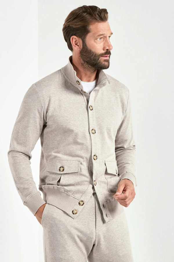 Man wearing a gray button-up shirt and pants on a white background