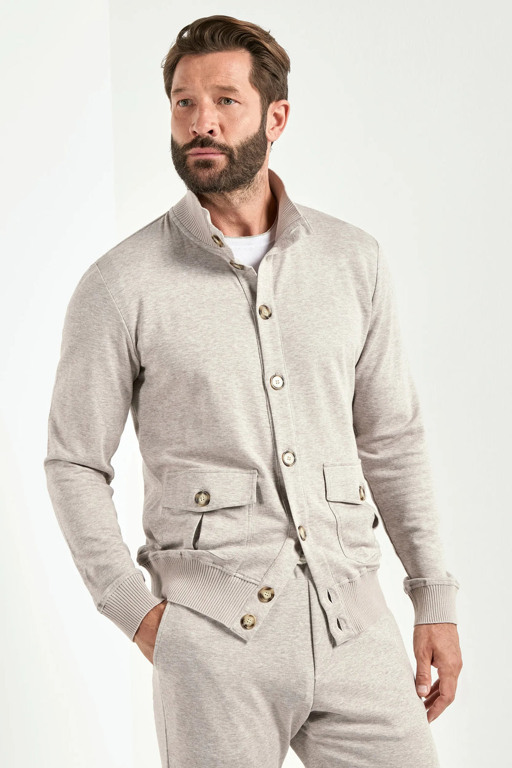 Man wearing a gray button-up outfit on a white background