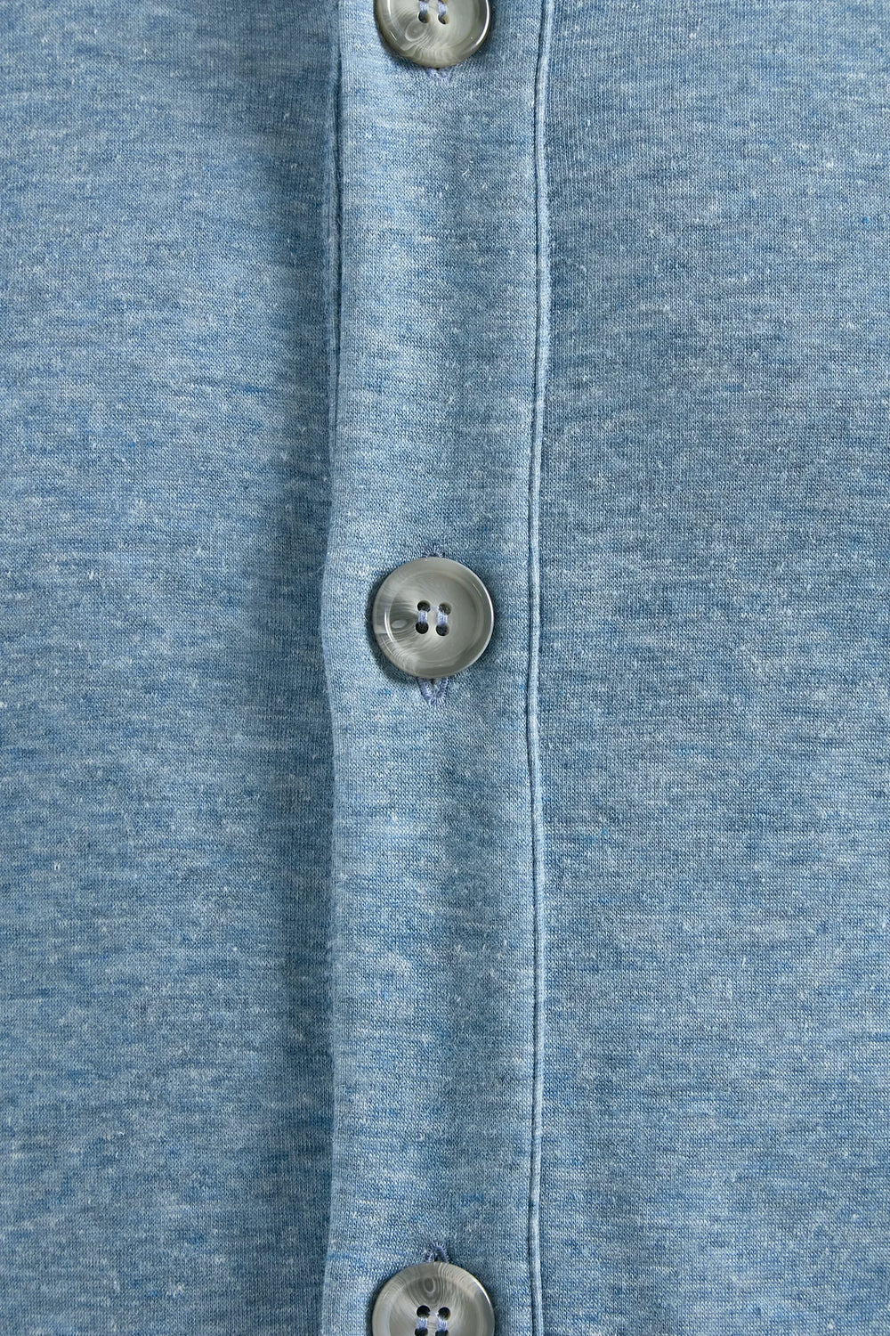 Close-up of a blue denim shirt with button details