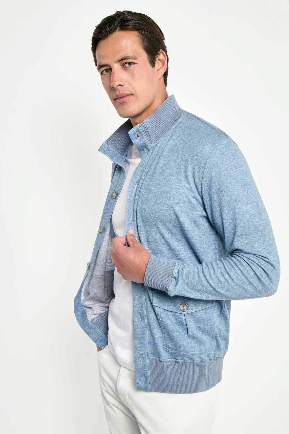 Man wearing a light blue cardigan over a white shirt on a white background