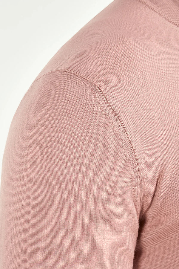 Close-up of a pink long-sleeve garment with a plain background