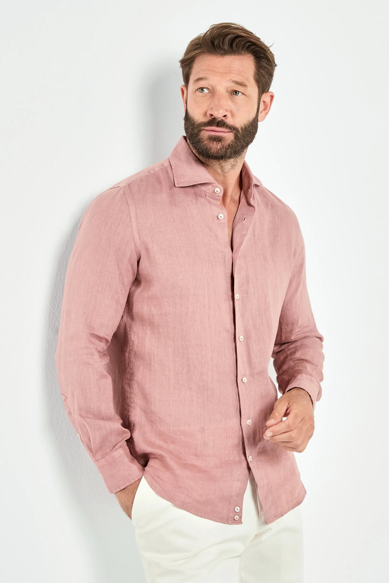 Man wearing a pink shirt against a white background