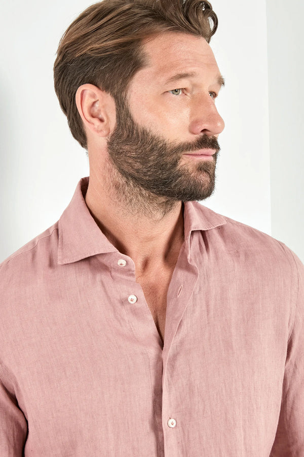 Man wearing a pink shirt against a white background
