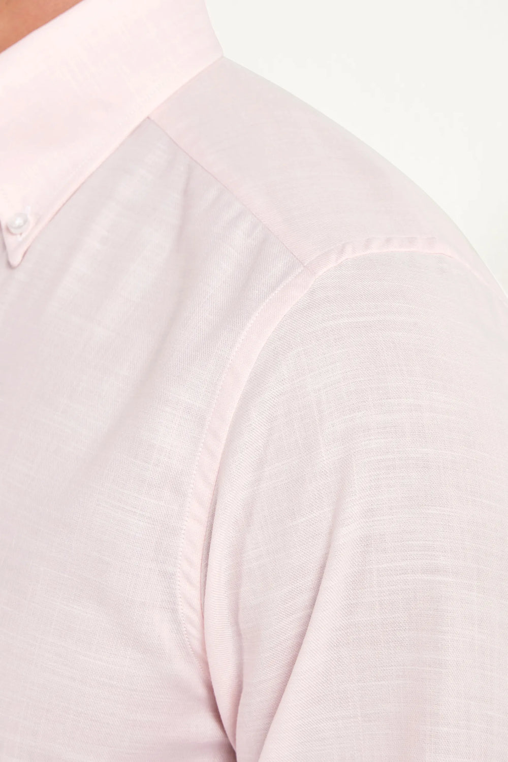 Close-up of a light pink long-sleeve shirt on a white background