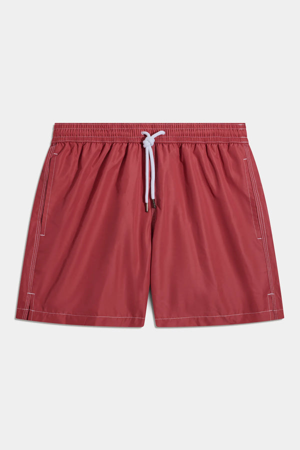 Red shorts with a white drawstring on a light gray background