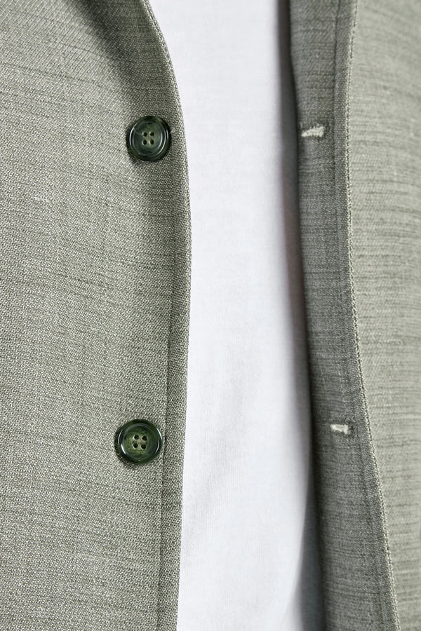 close up of an open jacket and buttons with a light background 