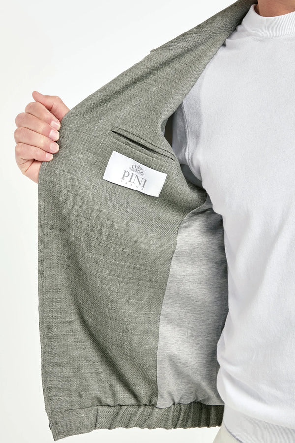 close up of a person holding the inside of his jacket with a brand label on a white background 