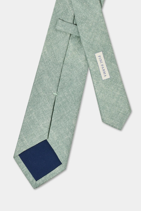 Green tie with a navy patch on a light gray background