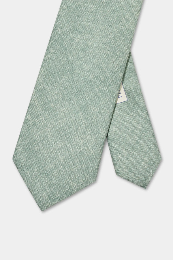Green tie with a subtle pattern on a light gray background