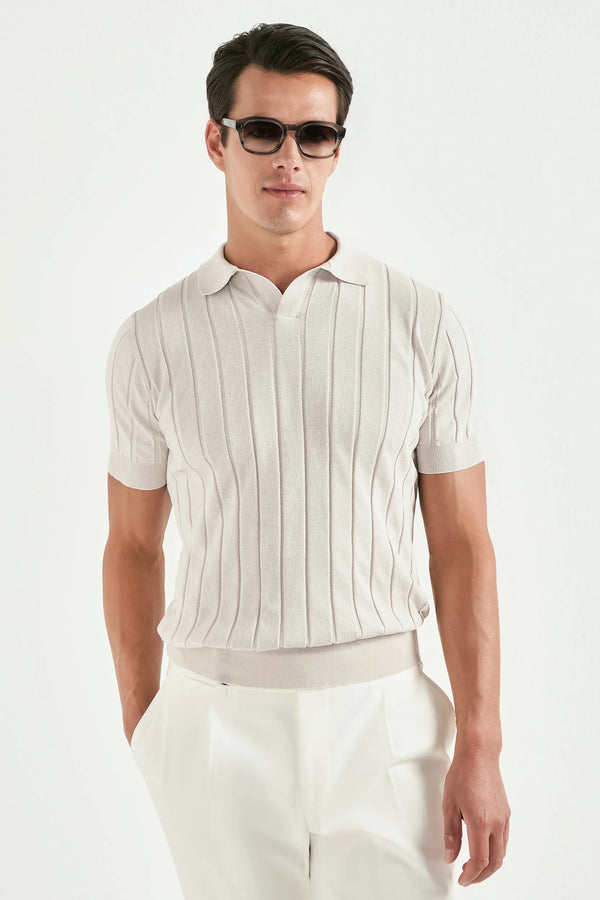 Man wearing a white striped polo shirt and white pants on a white background