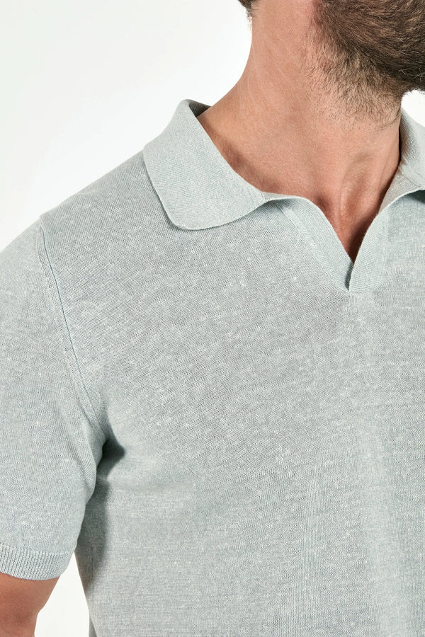 Close-up of a person wearing a light gray polo shirt with a collar.