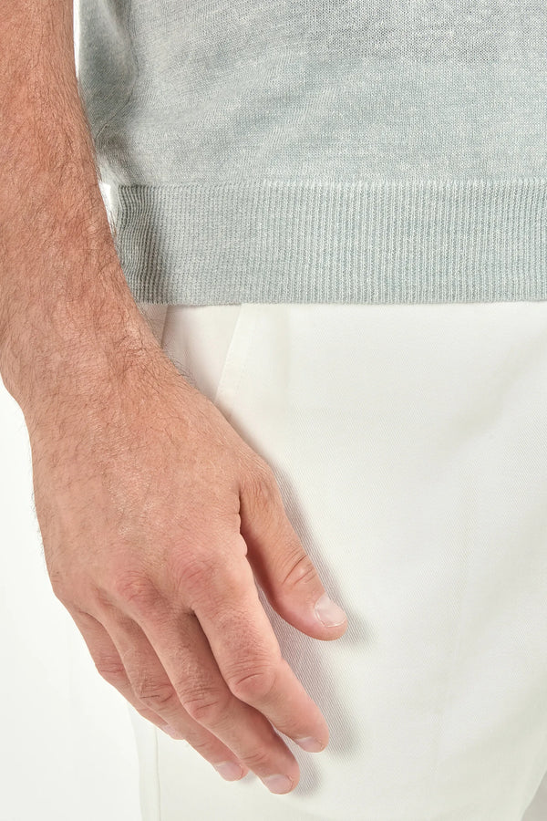 Close-up of a person's hand wearing a white glove on a light background