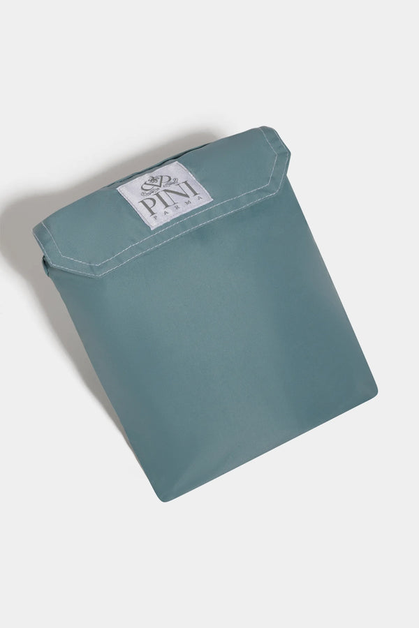 Teal pouch with a brand label on a light gray background