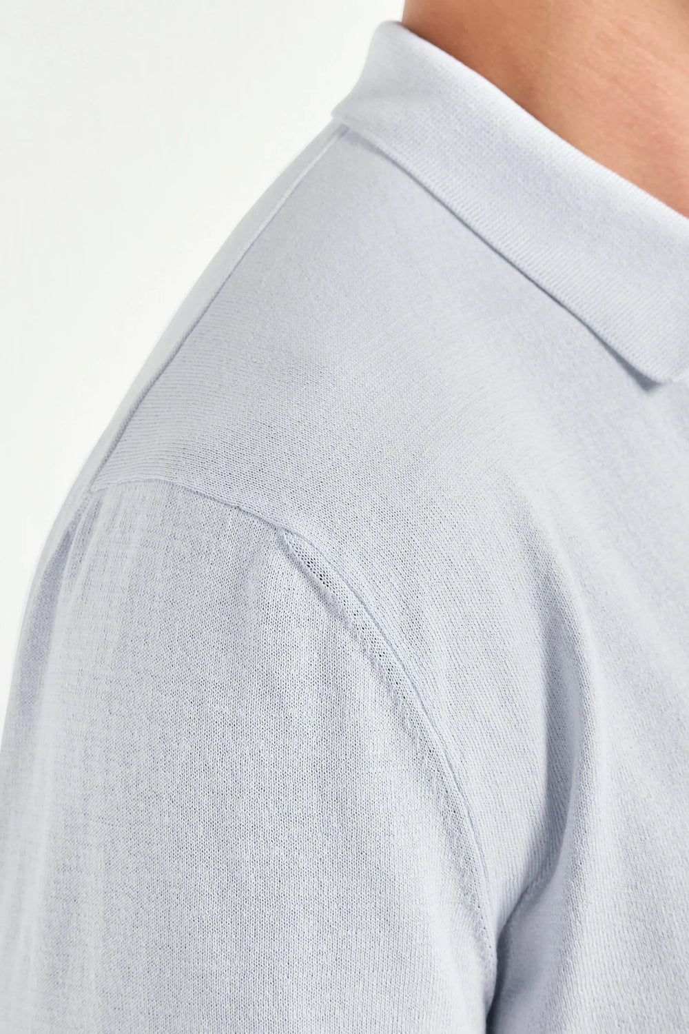 Close-up of a light gray polo shirt collar and shoulder area.
