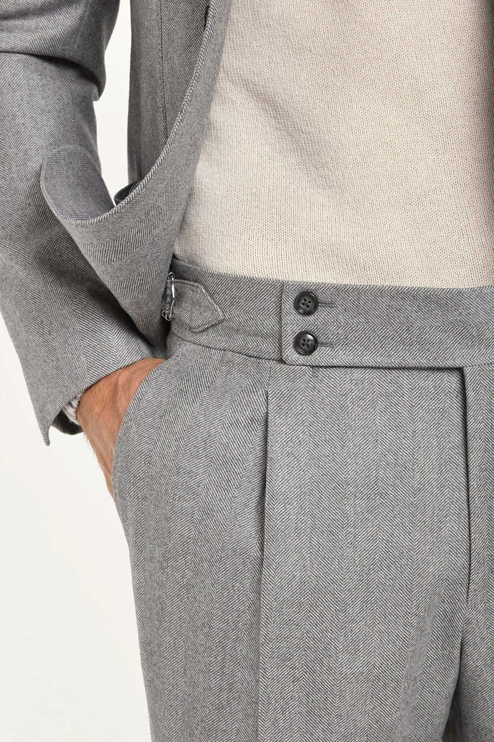 Light grey herringbone suit, Italian style, made in Italy, tailored luxury suit, elegant menswear suit, refined formalwear, premium Italian craftsmanship, classic herringbone weave suit, sophisticated business suit, smart formal attire, versatile modern suit, polished two-piece suit, fine Italian tailoring, upscale menswear suit, timeless Italian suit, refined professional look, sharp tailored suit, luxury office suit, contemporary herringbone blazer, Italian elegance suit