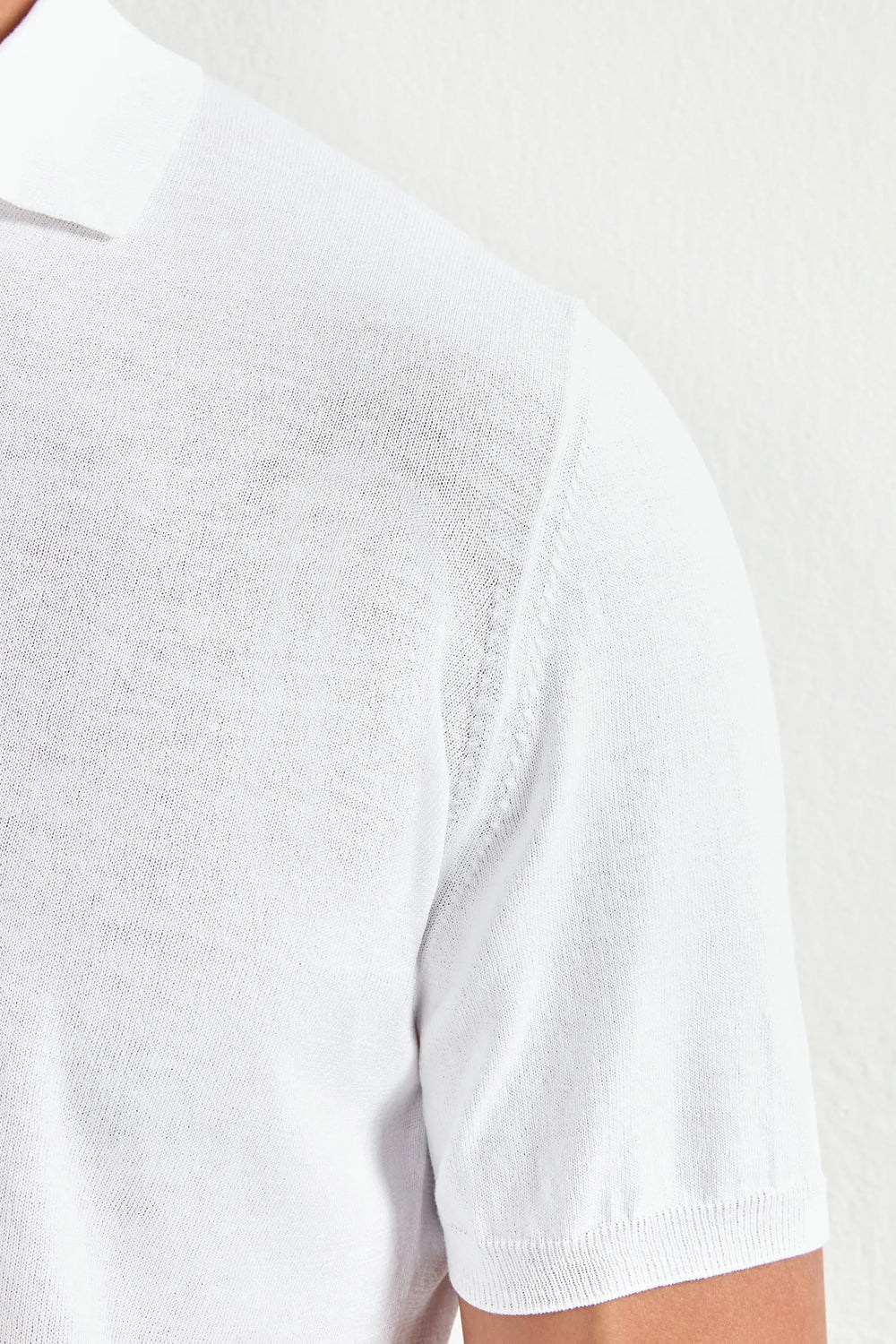 Close-up of a white polo shirt on a plain background